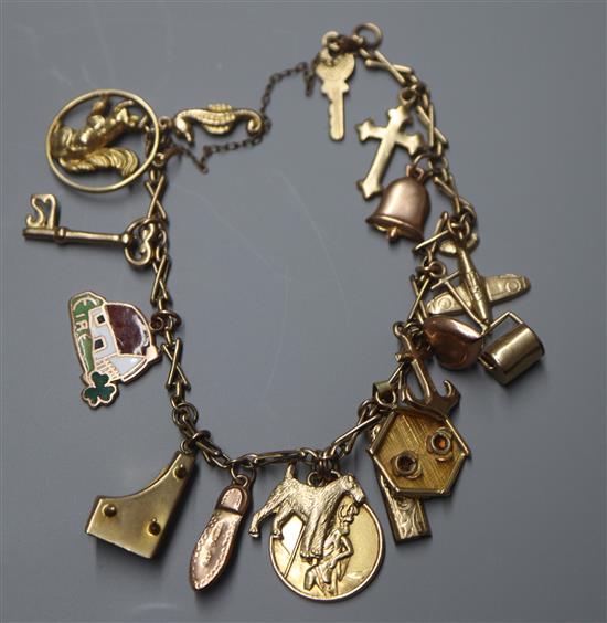 A 9ct charm bracelet, hung with assorted gold and yellow metal charms.